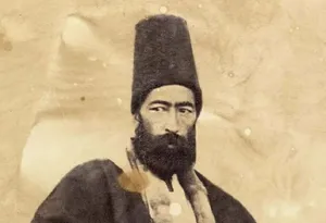 تصویری از «خطاط مشهور دوران قاجار» در کنار یکی از نوشته‌هایش